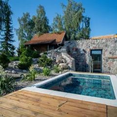 Relaks w klimatycznym spa w Polsce: basen, kamienna ściana z sauną i drewniany taras.