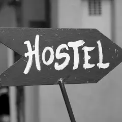 Strzałka z napisem "Hostel" wzywa podróżnych do taniego noclegu. To miejsce, gdzie można poznać innych turystów.