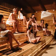 Relaks w saunie: grupa osób w **termy strefa dla dorosłych** odpoczywa na drewnianych ławach.