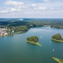 Widok z lotu ptaka na miasteczko nad jeziorem, z wyspami i żaglówkami. To jedno z najpiękniejszych jezior w Polsce.