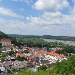 Widok na miasteczko z rzeką i wzgórzem. W oddali majaczy góra Trzech Krzyży.