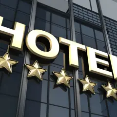 Złote litery "HOTEL" i pięć gwiazdek na nowoczesnym budynku. Spełnia hotel 4-gwiazdkowy wymagania luksusu i komfortu.