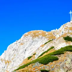 Góry z Giewontem, gdzie widać szlak turystów wspinających się na szczyt pod krzyżem.