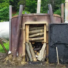 Wypał węgla drzewnego w Bieszczadach. Metalowe retorty z drewnem gotowym do przetworzenia.