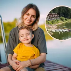 Uśmiechnięta mama z synkiem na pomoście, w tle jezioro z łódkami i domkami. Idealne miejsce na wakacje z bonem turystycznym.