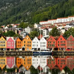 Kolorowe kamienice Bryggen w Bergen, wpisane na listę UNESCO, odbijają się w wodzie. Idealne miejsce, by zobaczyć, co oferuje to norweskie miasto.