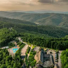 Malowniczy hotel ze spa w otoczeniu górskiego lasu, z basenem i zjeżdżalniami.