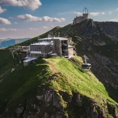 Kasprowy Wierch widok ze szczytu. Kolejka linowa wjeżdża na szczyt, gdzie znajdują się budynki obserwatorium i stacji meteorologicznej.
