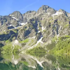 Morskie Oko, największe jezioro w Tatrach, odbija skaliste szczyty i zielone lasy w krystalicznie czystej wodzie.