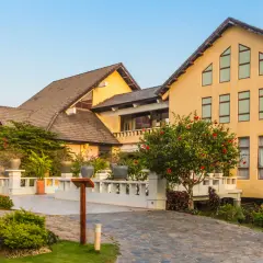 Elegancki hotel z żółtą fasadą i tarasami, otoczony bujną zielenią. Prawdopodobnie najbardziej luksusowy hotel w Polsce.