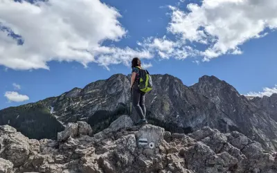 Widok z Sarniej Góry w Zakopanem. Turystka z plecakiem podziwia majestatyczne Tatry.