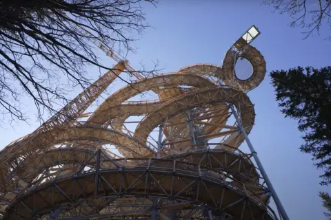 Drewniana konstrukcja wznosi się ku niebu, tworząc spiralne ścieżki. To najwyższa wieża widokowa w Polsce, oferująca niezwykłe widoki.