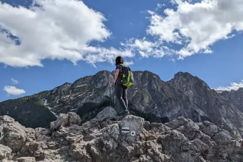 Widok z Sarniej Góry w Zakopanem. Turystka z plecakiem podziwia majestatyczne Tatry.