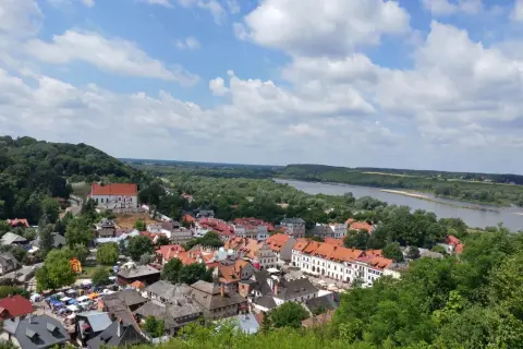 Widok na miasteczko z rzeką i wzgórzem. W oddali majaczy góra Trzech Krzyży.