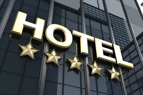 Złote litery "HOTEL" i pięć gwiazdek na nowoczesnym budynku. Spełnia hotel 4-gwiazdkowy wymagania luksusu i komfortu.