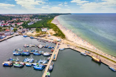 Jastrzębia Góra i okolice atrakcje: port rybacki, plaża pełna turystów, las i miasto.