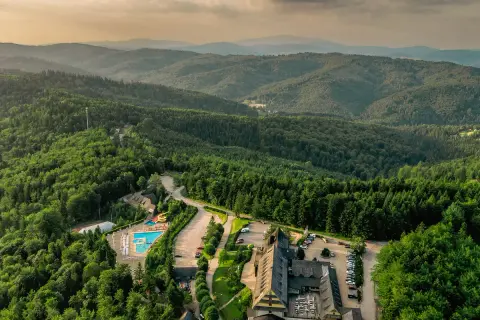 Malowniczy hotel ze spa w otoczeniu górskiego lasu, z basenem i zjeżdżalniami.