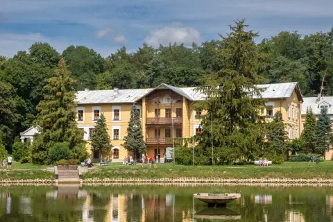Żółty dworek nad stawem, otoczony drzewami, to idealne miejsce, by sprawdzić, co warto zobaczyć w Nałęczowie.