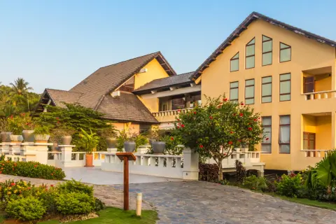 Elegancki hotel z żółtą fasadą i tarasami, otoczony bujną zielenią. Prawdopodobnie najbardziej luksusowy hotel w Polsce.