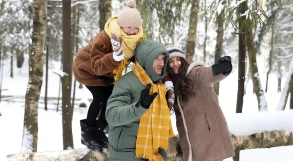 Rodzina robi selfie podczas ferii zimowych 2026 w województwie śląskim. Dziecko na rękach ojca, mama obok.