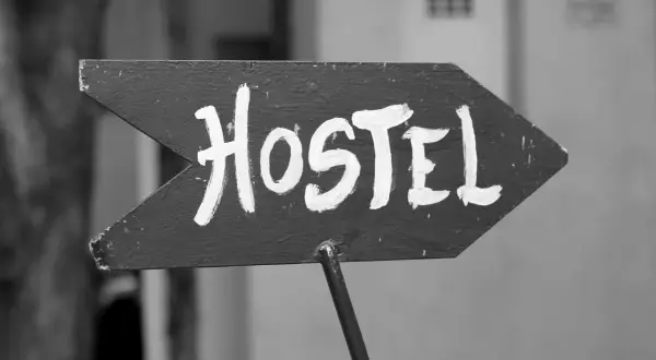Strzałka z napisem "Hostel" wzywa podróżnych do taniego noclegu. To miejsce, gdzie można poznać innych turystów.