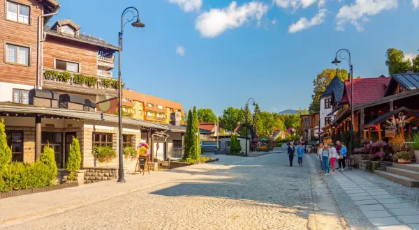 Urokliwe miasta w górach, z brukowaną uliczką, drewnianymi domami i zielenią.