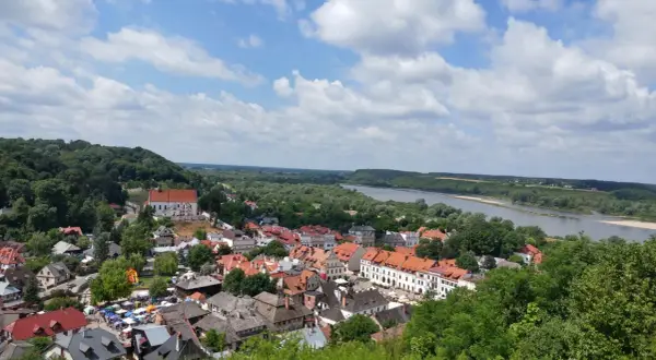 Widok na miasteczko z rzeką i wzgórzem. W oddali majaczy góra Trzech Krzyży.