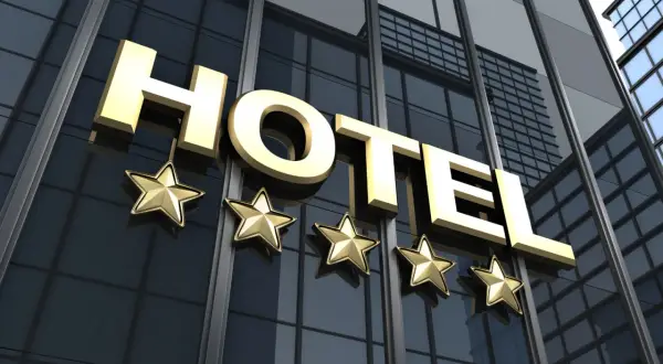 Złote litery "HOTEL" i pięć gwiazdek na nowoczesnym budynku. Spełnia hotel 4-gwiazdkowy wymagania luksusu i komfortu.