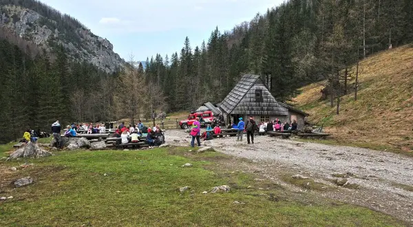 Grupa turystów odpoczywa przy bacówce w Dolinie Strążyskiej. To popularne miejsce, gdzie warto wiedzieć, jak dojechać do doliny strążyskiej.