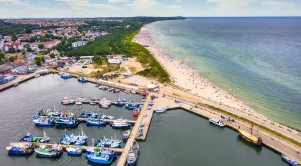 Jastrzębia Góra i okolice atrakcje: port rybacki, plaża pełna turystów, las i miasto.