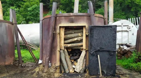 Wypał węgla drzewnego w Bieszczadach. Metalowe retorty z drewnem gotowym do przetworzenia.