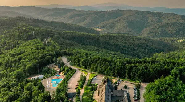 Malowniczy hotel ze spa w otoczeniu górskiego lasu, z basenem i zjeżdżalniami.