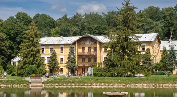 Żółty dworek nad stawem, otoczony drzewami, to idealne miejsce, by sprawdzić, co warto zobaczyć w Nałęczowie.