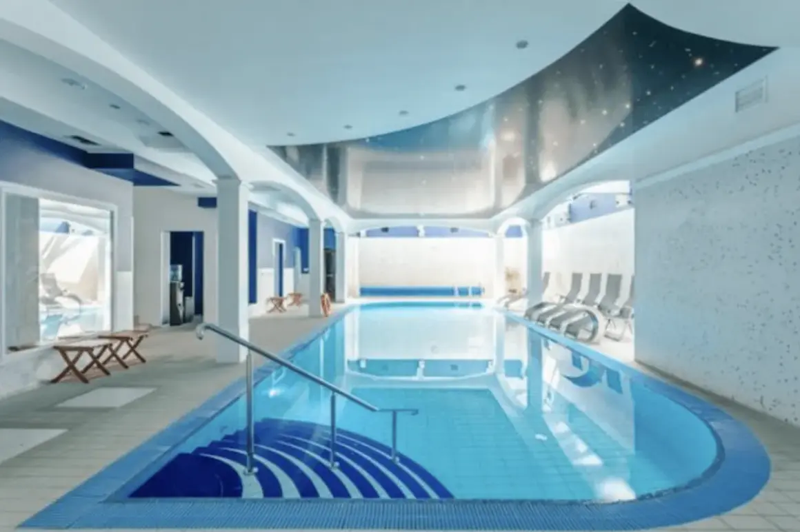 Relaks w spa nad morzem z basenem. Wnętrze z basenem, leżakami i niebieskimi akcentami.
