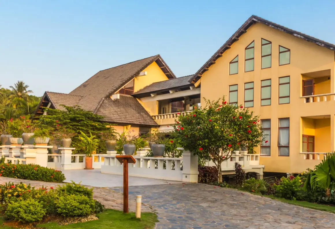 Elegancki hotel z żółtą fasadą i tarasami, otoczony bujną zielenią. Prawdopodobnie najbardziej luksusowy hotel w Polsce.
