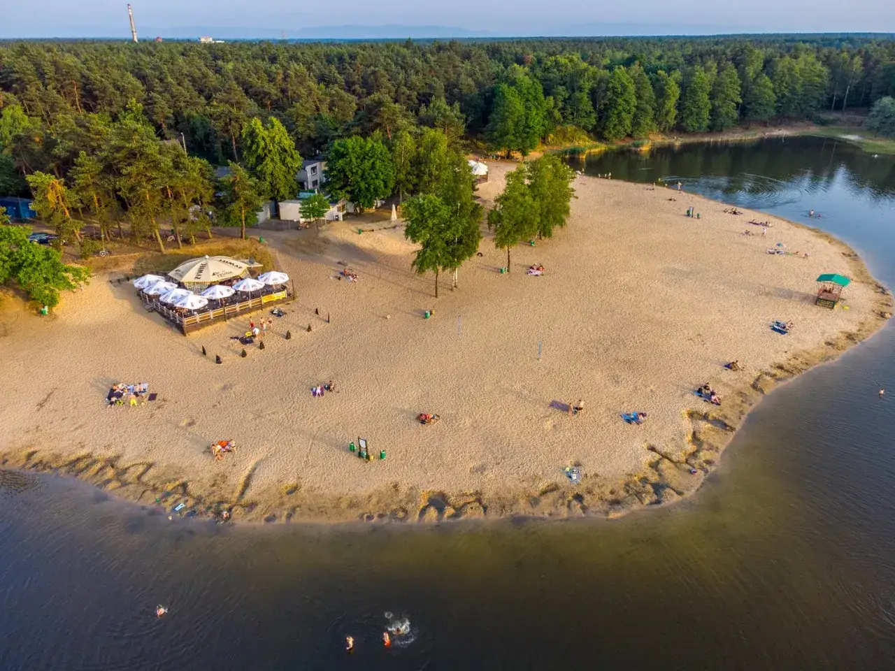 Idealne miejsce gdzie nad jezioro, by odpocząć na piaszczystej plaży, zrelaksować się przy barze i popływać w czystej wodzie.