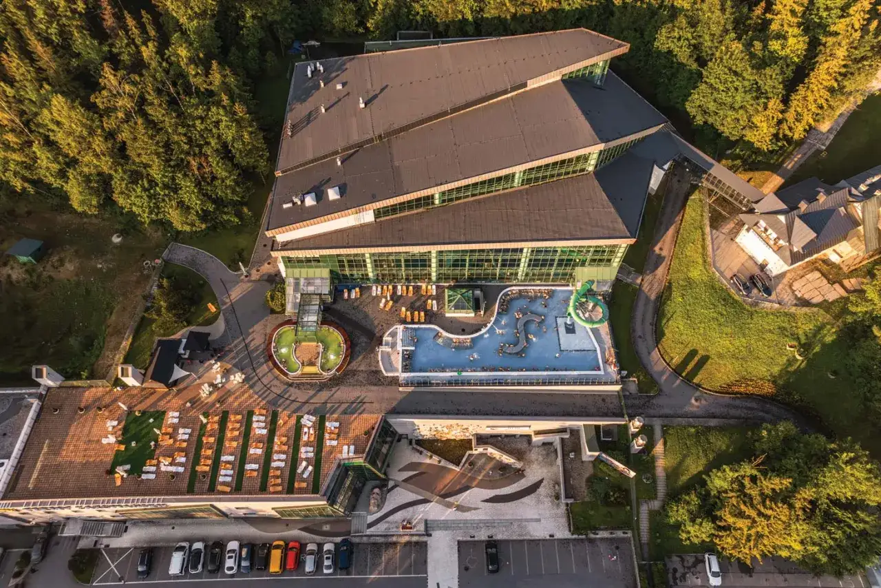 Hotel z basenami i zjeżdżalniami, oferujący liczne usługi uzupełniające. Relaks na leżakach i wodne atrakcje dla gości.