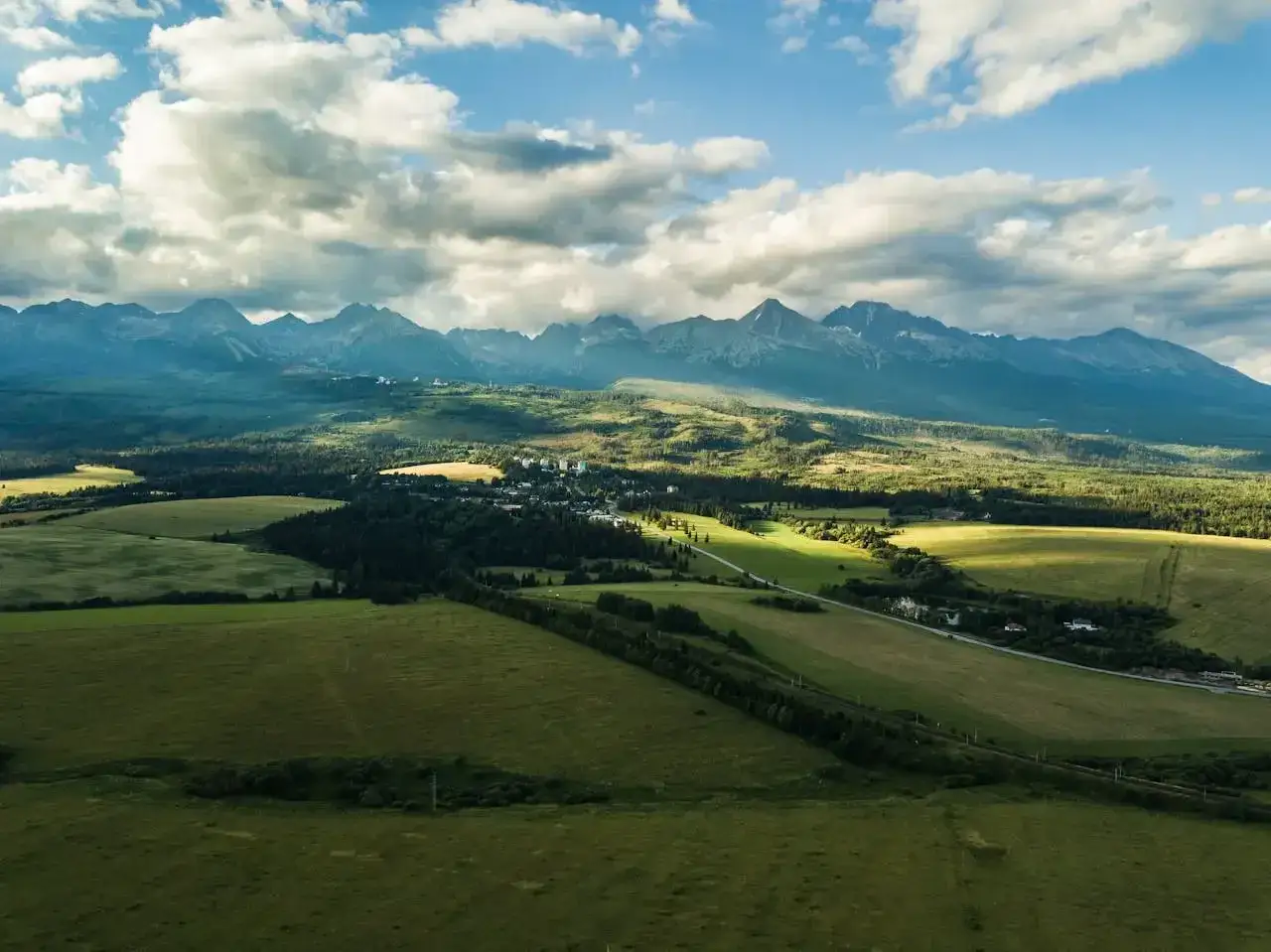 Piękne Tatry, idealne miejsce, gdzie na weekend. Zielone pola, lasy i góry pod błękitnym niebem.