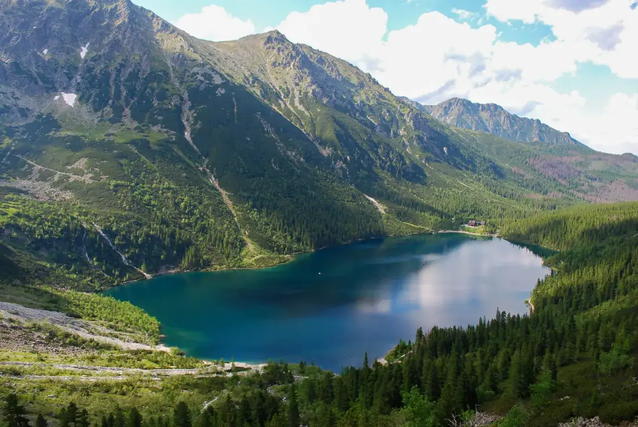 Morskie Oko, największe jezioro w Tatrach, otoczone zielonymi lasami i skalistymi szczytami.