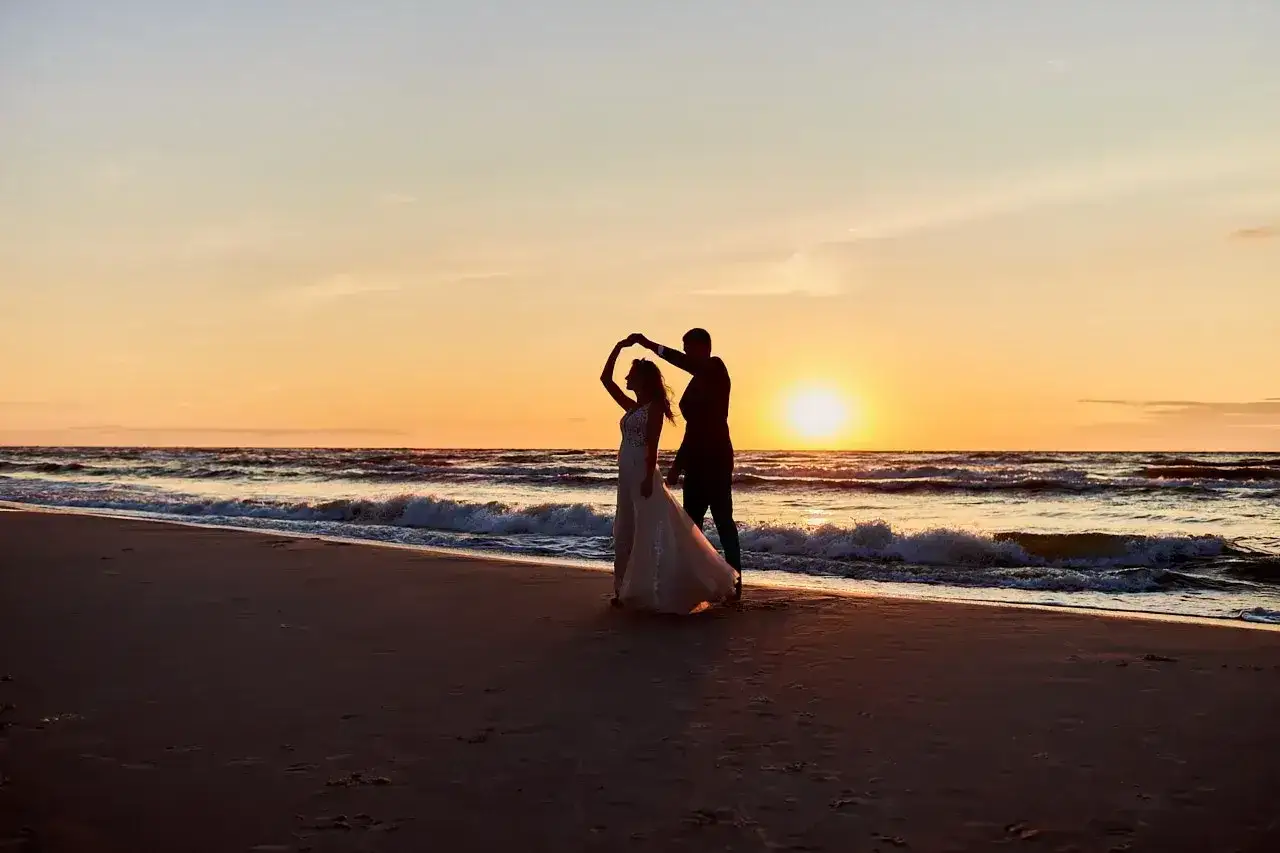 Para tańcząca na plaży o zachodzie słońca. Romantyczne miejsca, najpiękniejsze miejsca w Polsce.