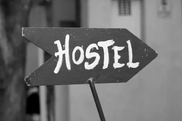 Strzałka z napisem "Hostel" wzywa podróżnych do taniego noclegu. To miejsce, gdzie można poznać innych turystów.