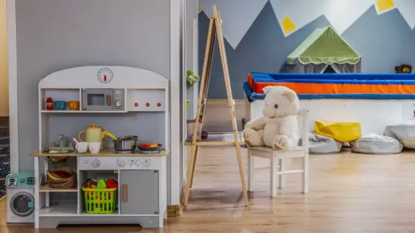 Uroczy pokój zabaw z kuchnią, pralką i pluszowym misiem. Idealne miejsce dla dzieci, jak w najlepszych hotelach dla dzieci.