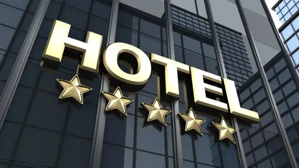 Złote litery "HOTEL" i pięć gwiazdek na nowoczesnym budynku. Spełnia hotel 4-gwiazdkowy wymagania luksusu i komfortu.