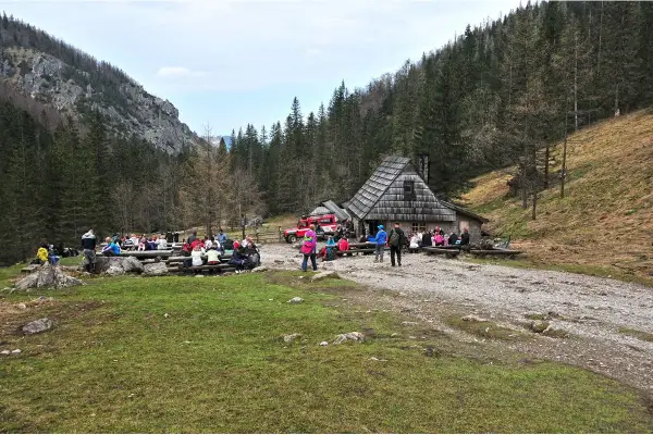Grupa turystów odpoczywa przy bacówce w Dolinie Strążyskiej. To popularne miejsce, gdzie warto wiedzieć, jak dojechać do doliny strążyskiej.
