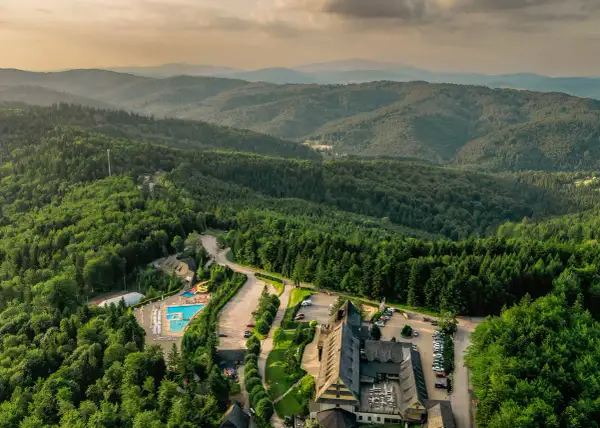 Malowniczy hotel ze spa w otoczeniu górskiego lasu, z basenem i zjeżdżalniami.