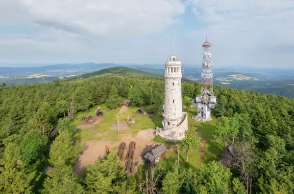 Wieża widokowa i maszt telekomunikacyjny na szczycie góry. Wokół las i polana z ławkami. Wielka sowa trasa zaprasza do podziwiania panoramy.